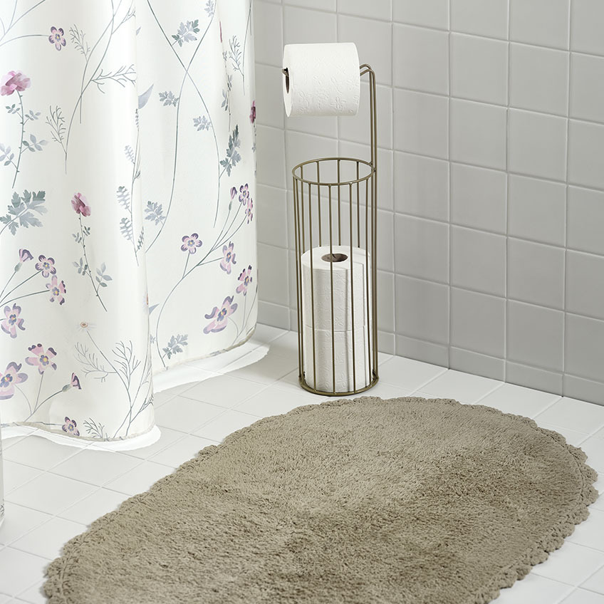 Rideau de douche, tapis de bain et porte-rouleau WC dans une salle de bains