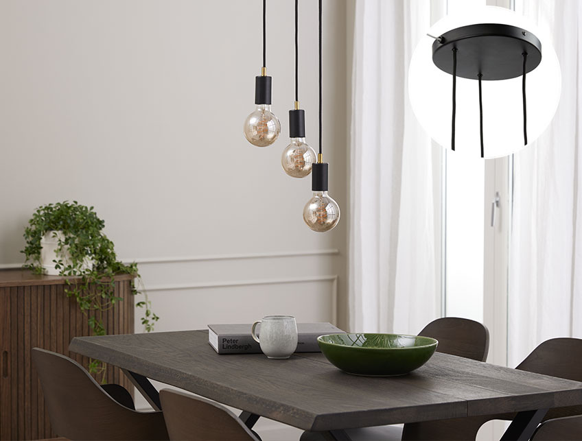 Zwarte hanglamp met grote ledlampen boven een eettafel