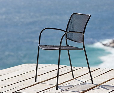 Chaise empilable en acier noir sur une terrasse