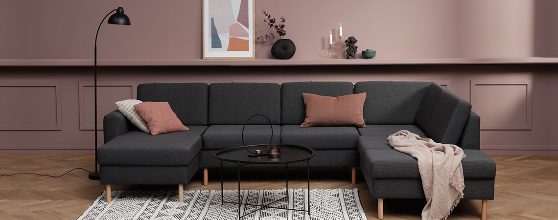 Grand canapé d'angle gris avec des coussins et un jet dans un salon moderne