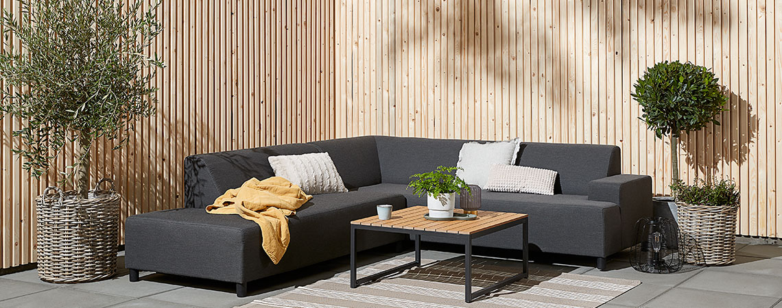 Canapé lounge gris dans un coin sur une terrasse