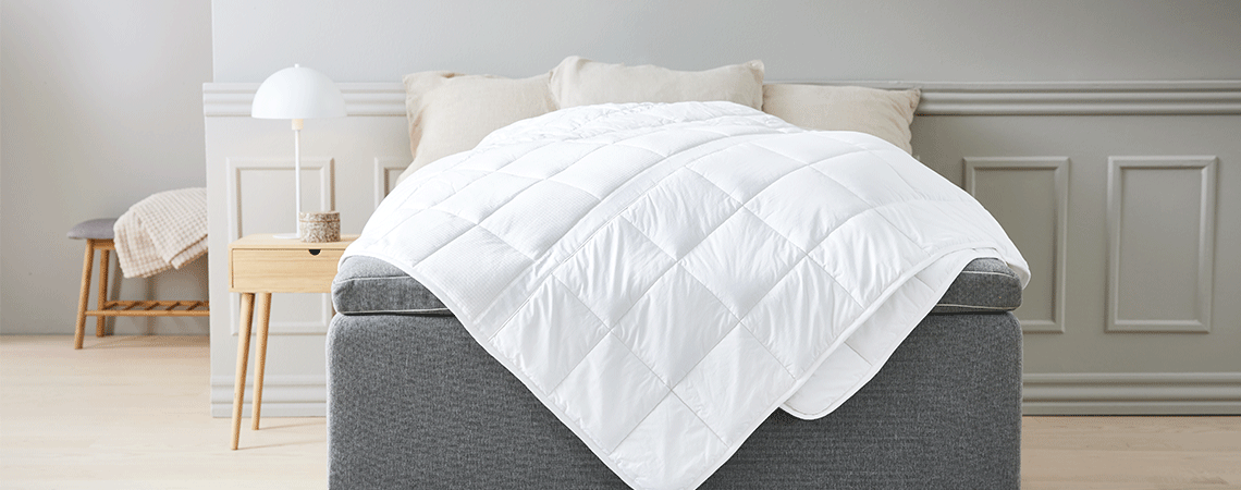 Scandinavische slaapkamer met kingsize bed met dekbedden en kussens