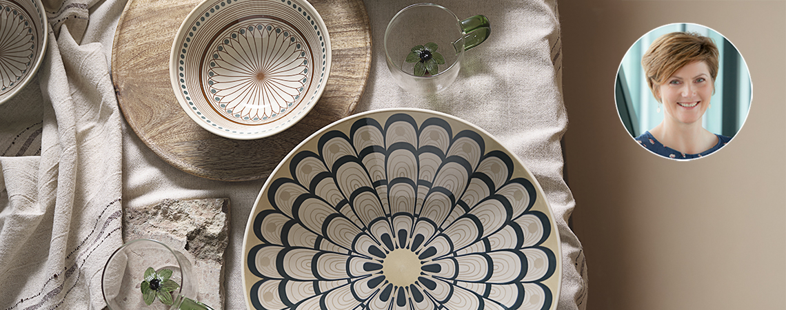 Table dressée avec une nappe, un grand bol, un petit bol et une tasse avec un palmier. Encart de Tina Nymann