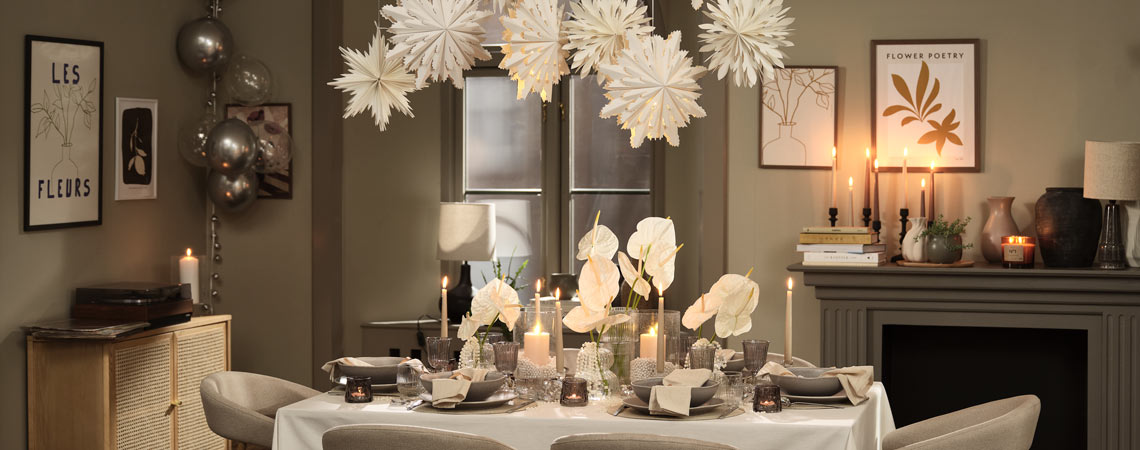 SKRYMSLI kerststerren sieren de oudejaarsavondtafel. Eetkamer met eettafel gedekt voor een feestelijke avond.