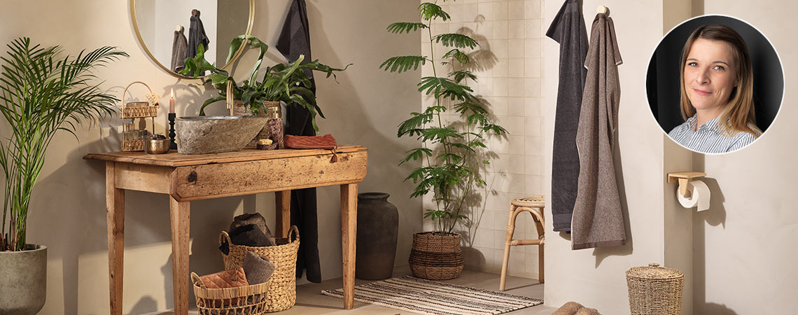 Salle de bains équipée de serviettes, d’un distributeur de savon, d’un porte-bijoux et d’un tapis de bain rayé