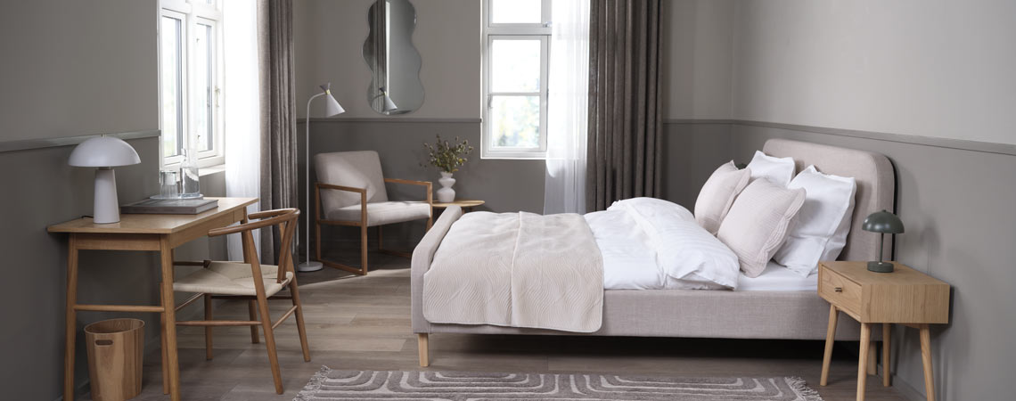 Gestoffeerd bedframe in een slaapkamer met kantoorruimte