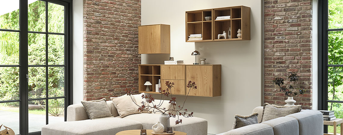 Opbergmeubel bestaande uit meerdere wandkasten die aan een muur in een woonkamer zijn bevestigd