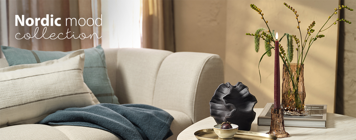 Salon avec un canapé et une table basse avec un vase en verre et un chandelier