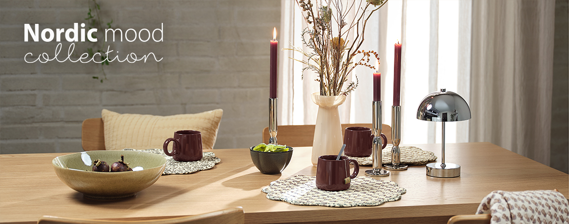 Eettafel met schalen, mokken, placemats, vaas, kandelaars en batterijlamp