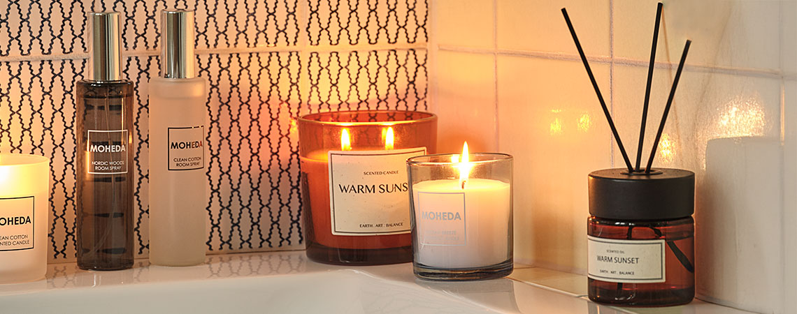 Salle de bains avec bougies parfumées, diffuseur à bâtonnets et vaporisateurs de parfum d'ambiance