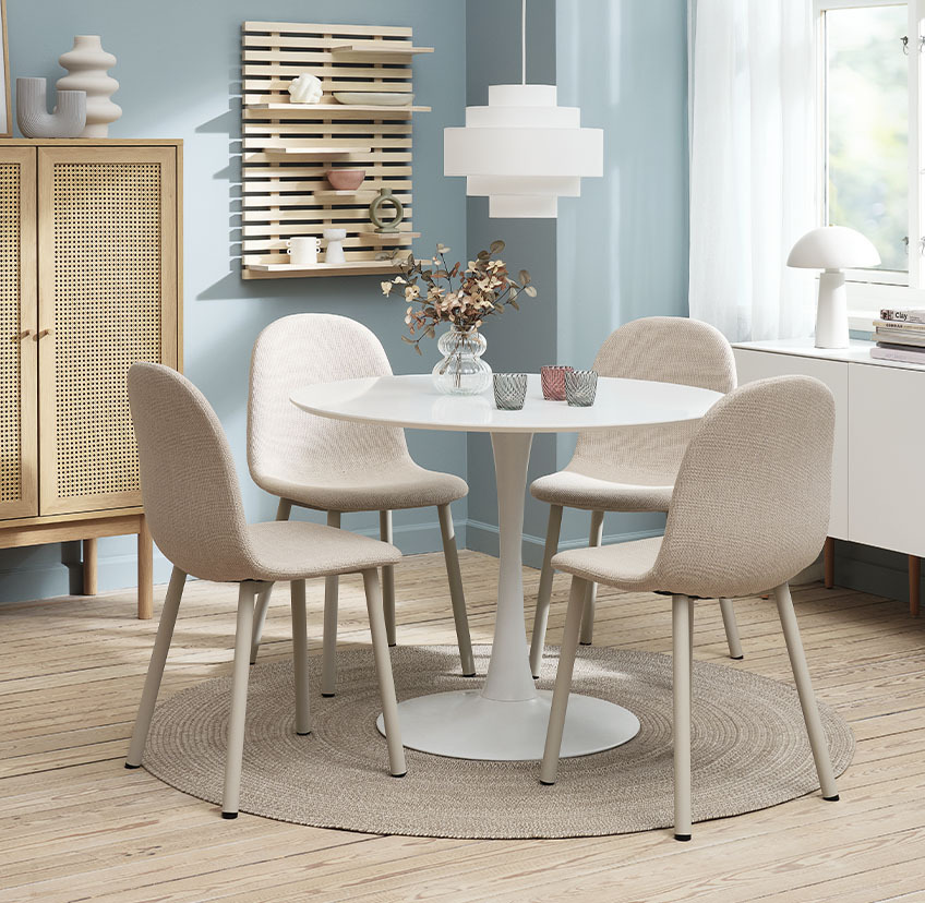 Lichtbeige stoelen rond een ronde, witte eettafel