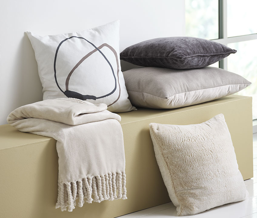 POPPEL witte kussenhoes met print Witte kussenhoes met grafische print en fleeceplaid op een bankje