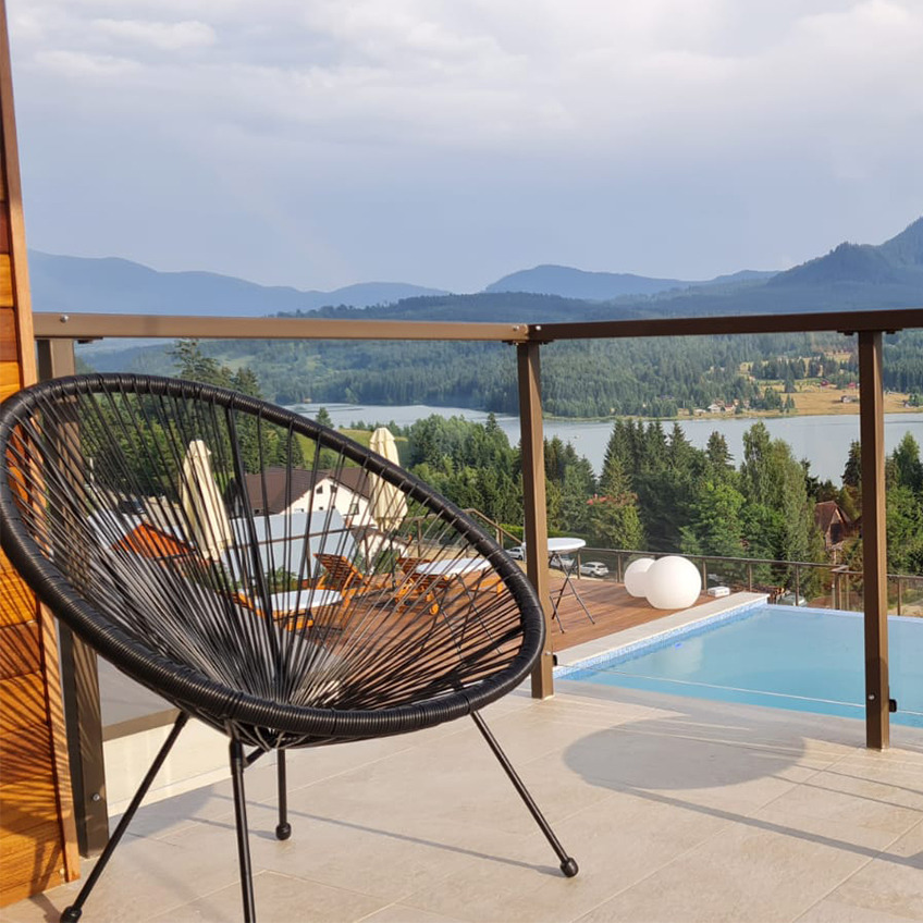 Zone piscine meublée avec chaise et montagnes en arrière-plan