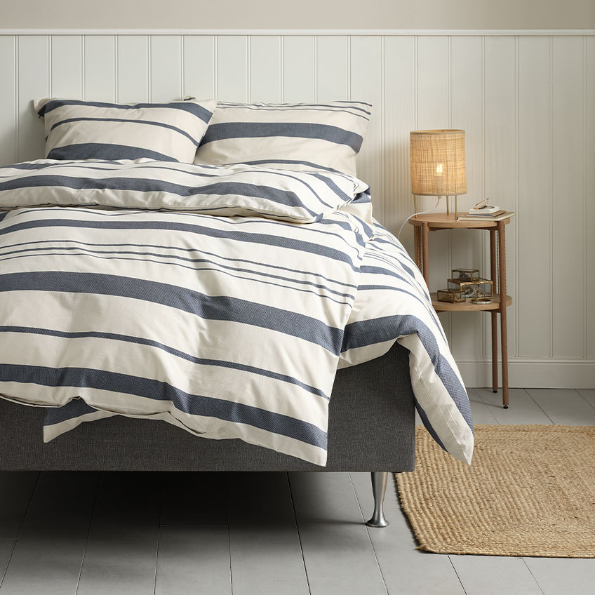 Katoenen dekbedovertrekset in wit met blauwe strepen op bed in slaapkamer 