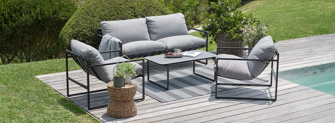 Tuin loungeset met loungebank, loungestoelen en loungetafel in tuin naast zwembad