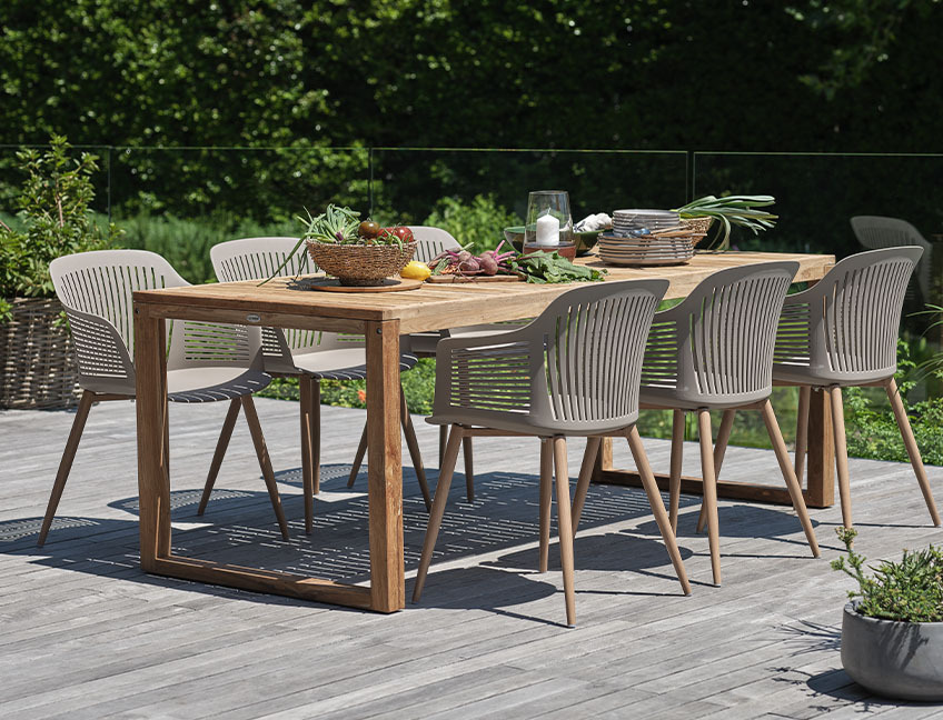 Table de jardin en bois et chaises de jardin sur terrasse dans un jardin