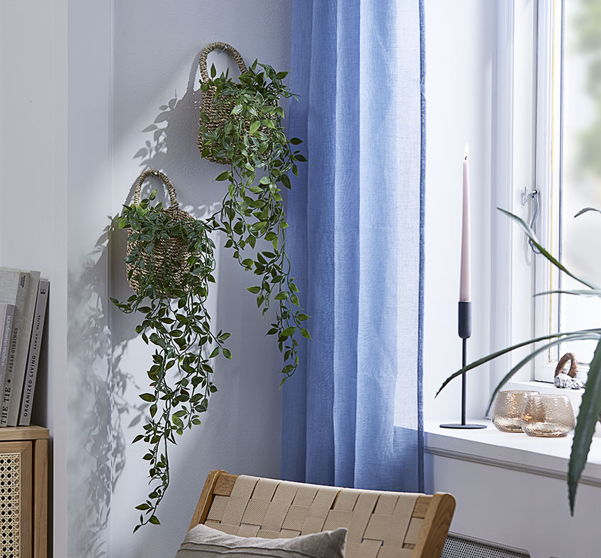 Twee manden met kunstplanten aan de muur in de woonkamer