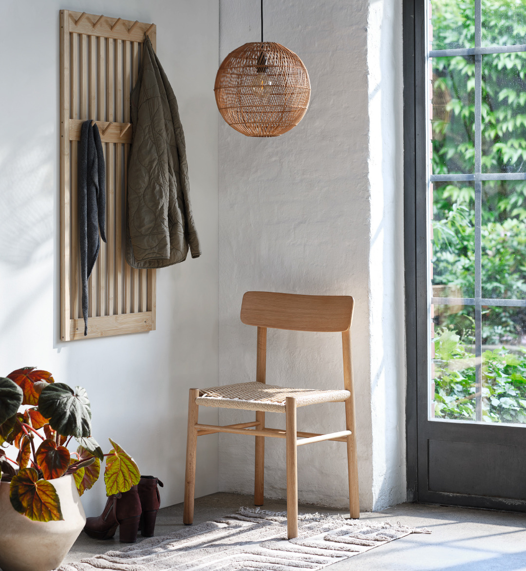 Chaise en corde tressée dans une entrée, patère en bambou et suspension en rotin