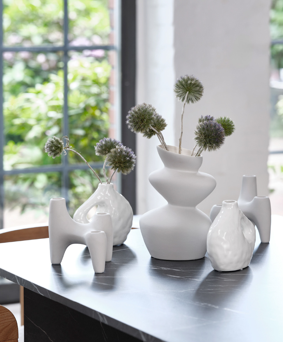 Vases et bougeoir décoratifs sur une table de salle à manger