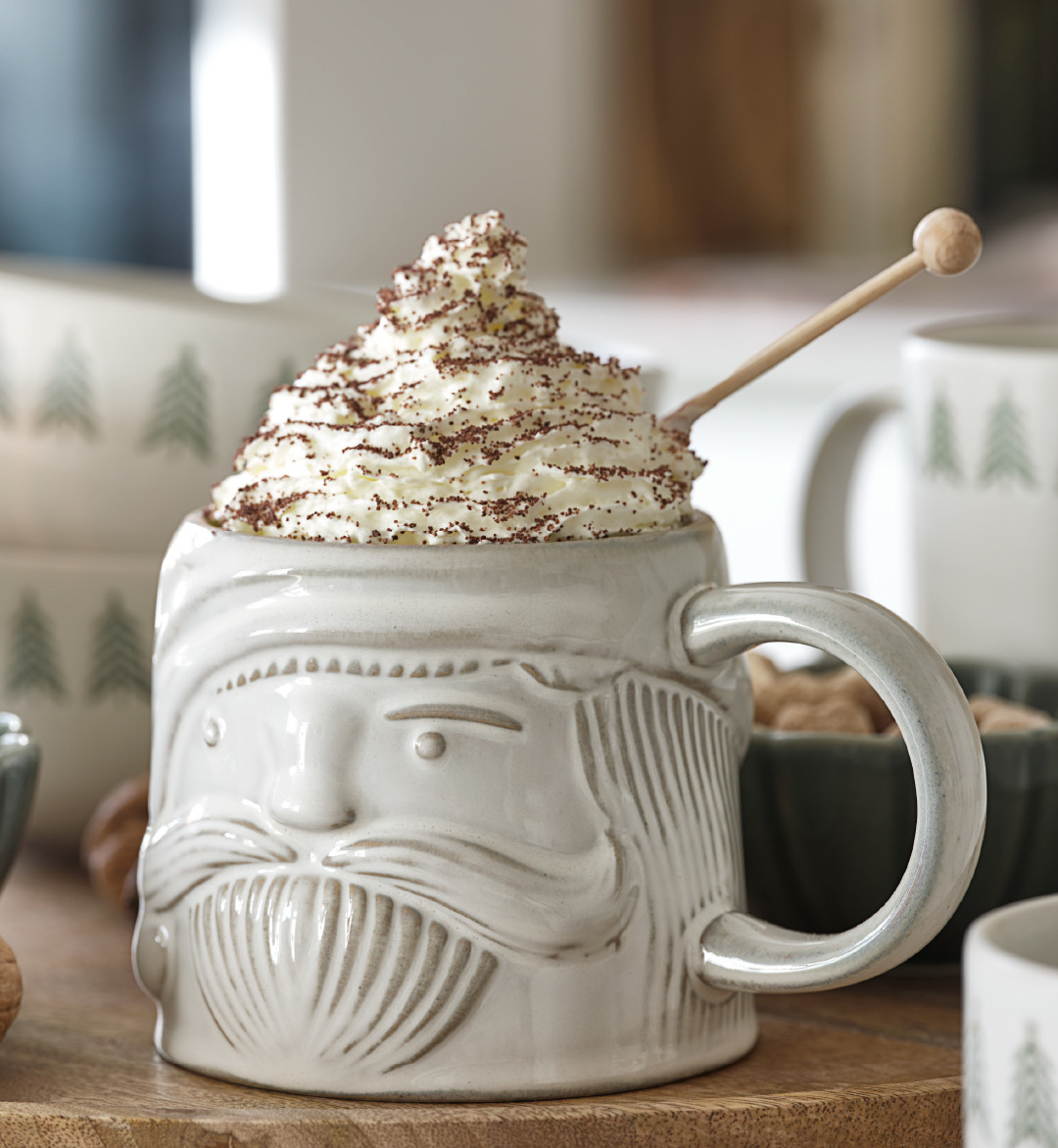 Tasse de Noël avec un chapeau crème solide et une pincée de cacao