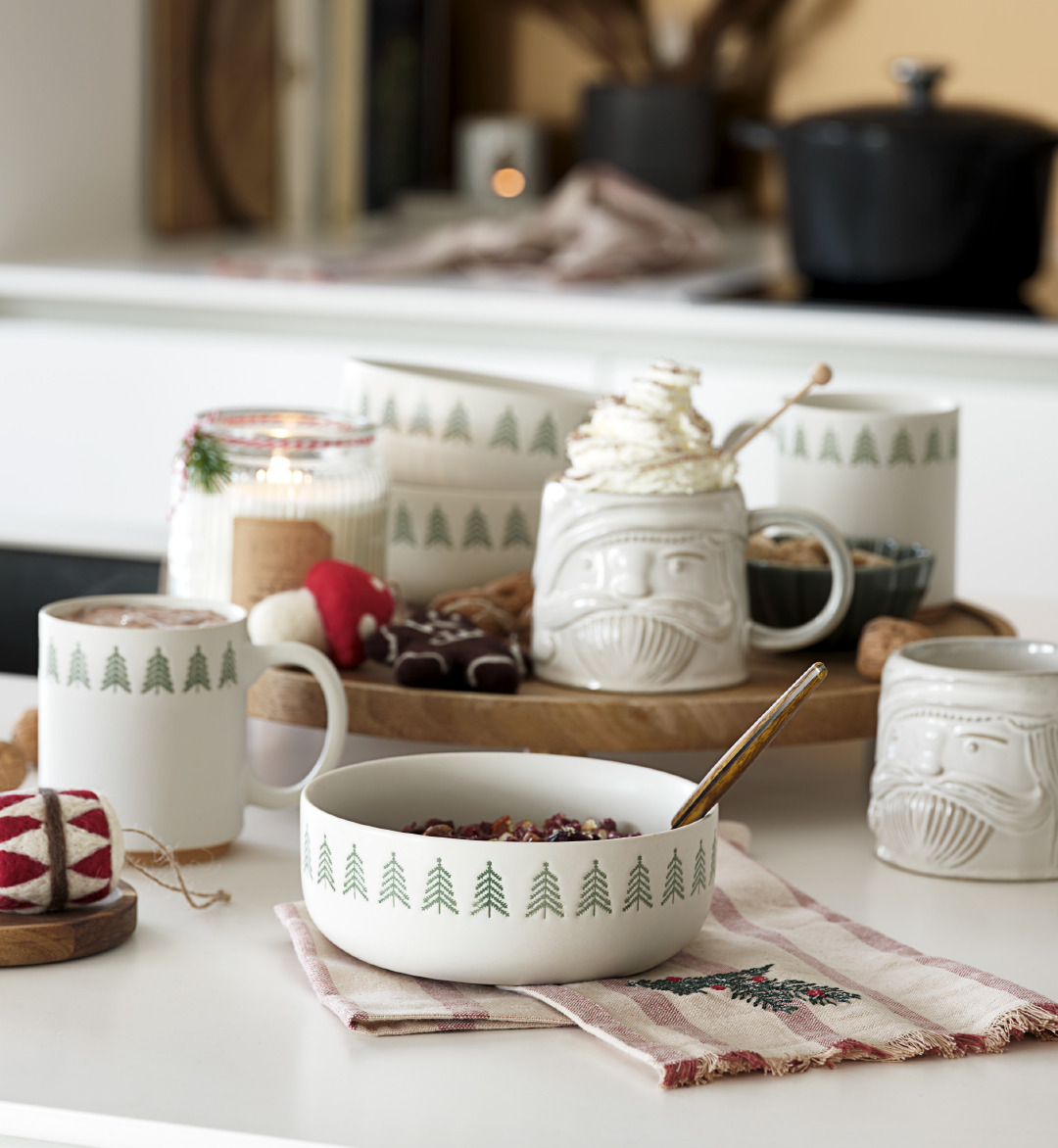Kom en mokken FREKI, mok PYNT, theedoek TEKTIT Gedekte tafel met kerstservies en decoratie