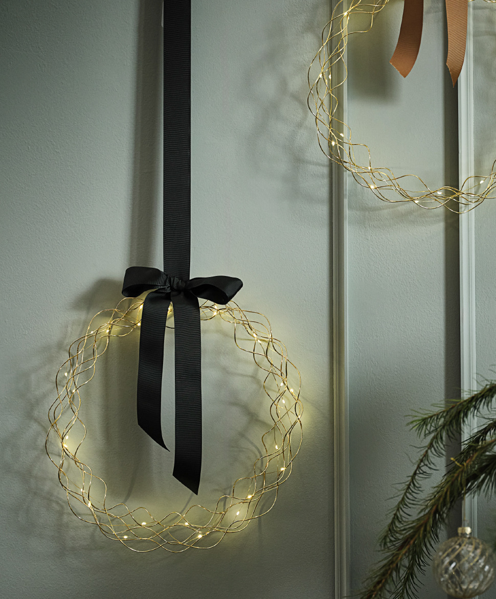 Kerstkrans SNE Lichtkrans met strik tegen groene wand