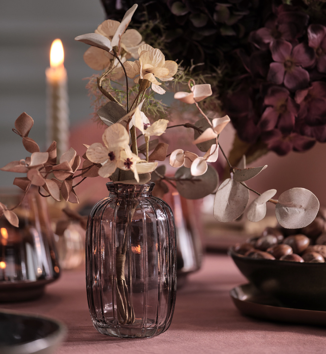 Vase en verre gris avec des fleurs artificielles sur une table