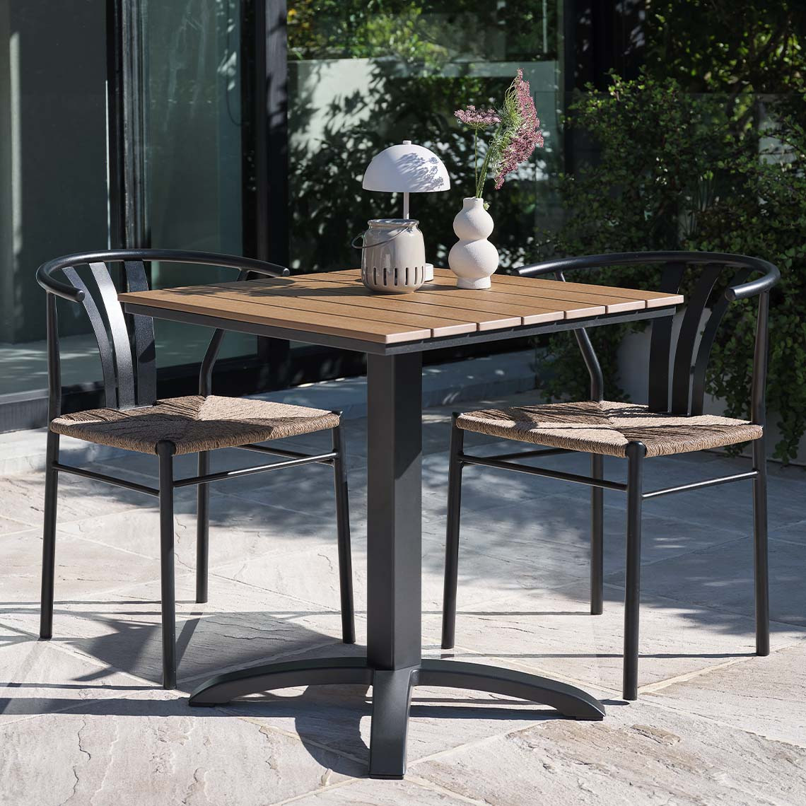 Onderhoudsvrije tuintafel en tuinstoelen in moderne stijl op patio 