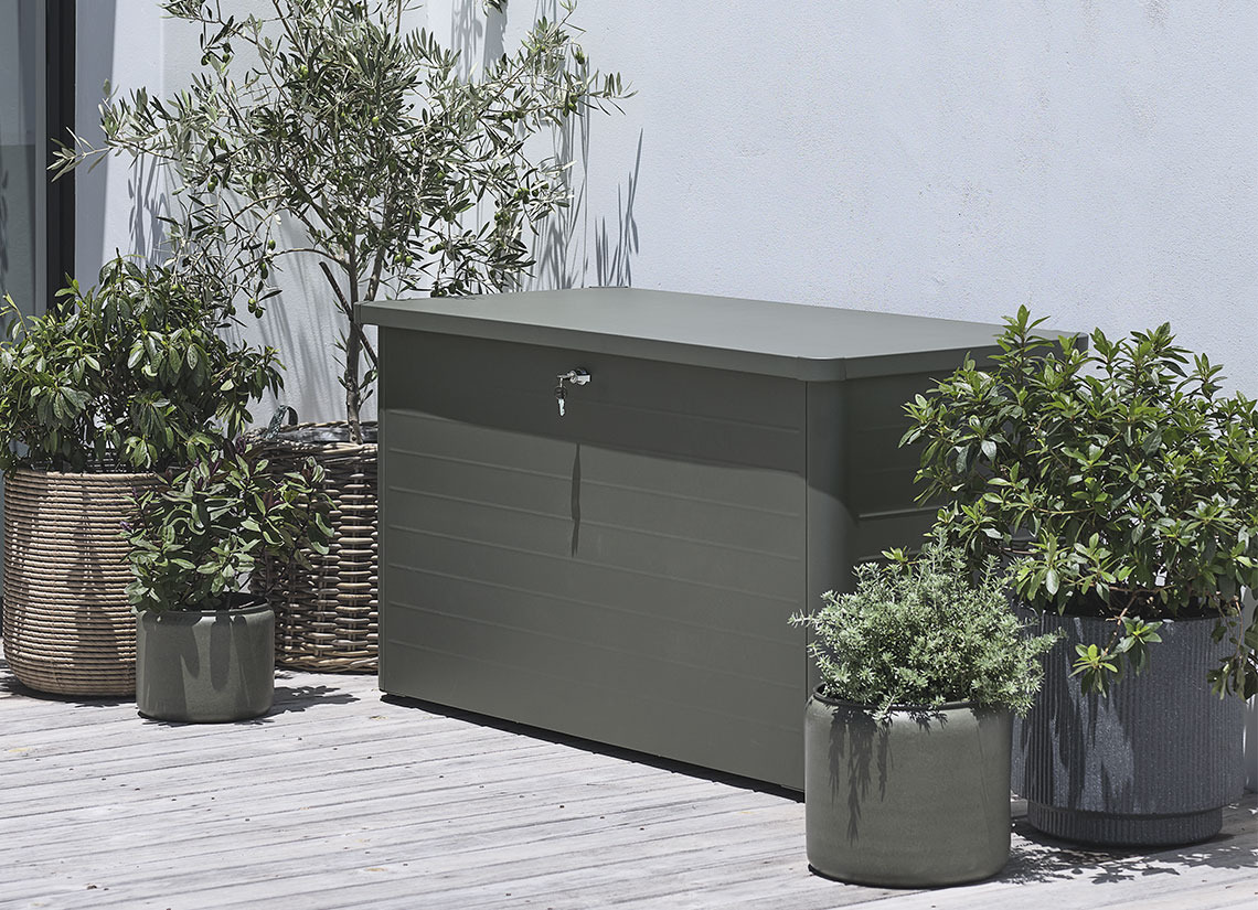 Grijze tuinkussenbak op terras met planten en plantenbakken