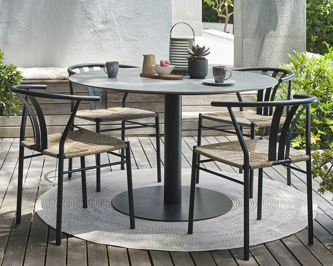 Tuintafel met pedestal en vier tuinstoelen op terras