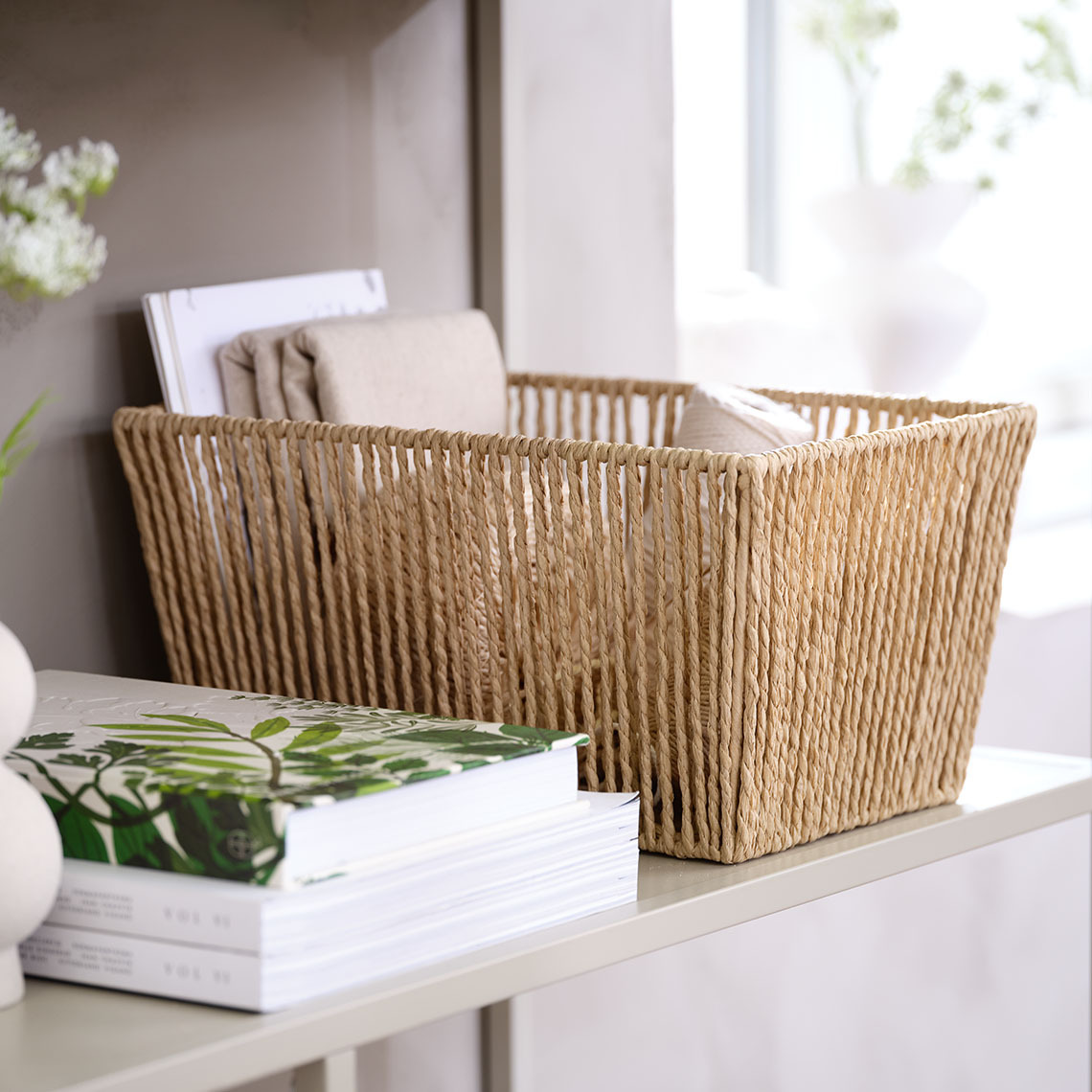 La corbeille LARSEMIL est aérée et douce au toucher grâce aux fils de papier tressés. Panier décoratif en brins de papier tressés