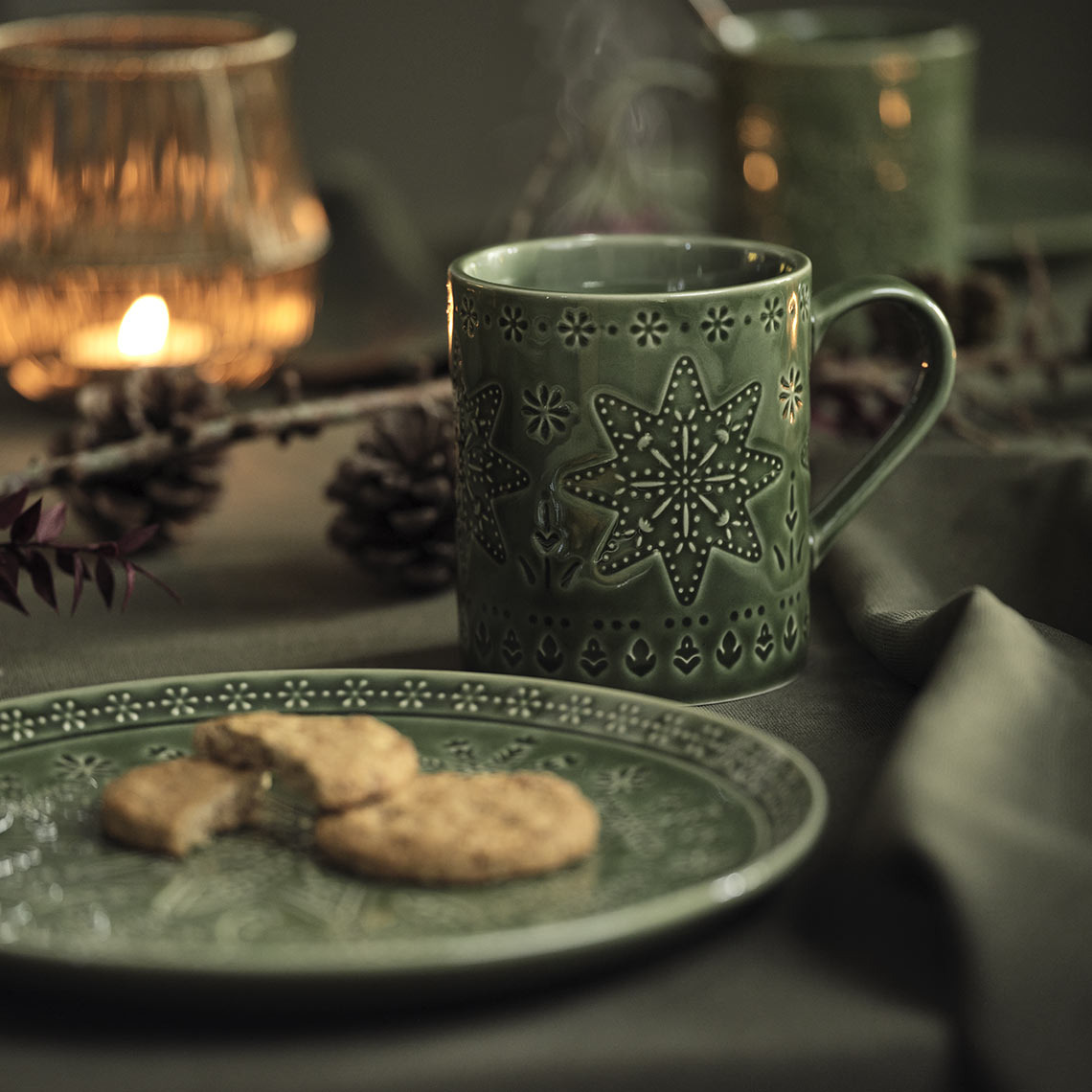 Groene kerstbord en mok op een kersttafel 