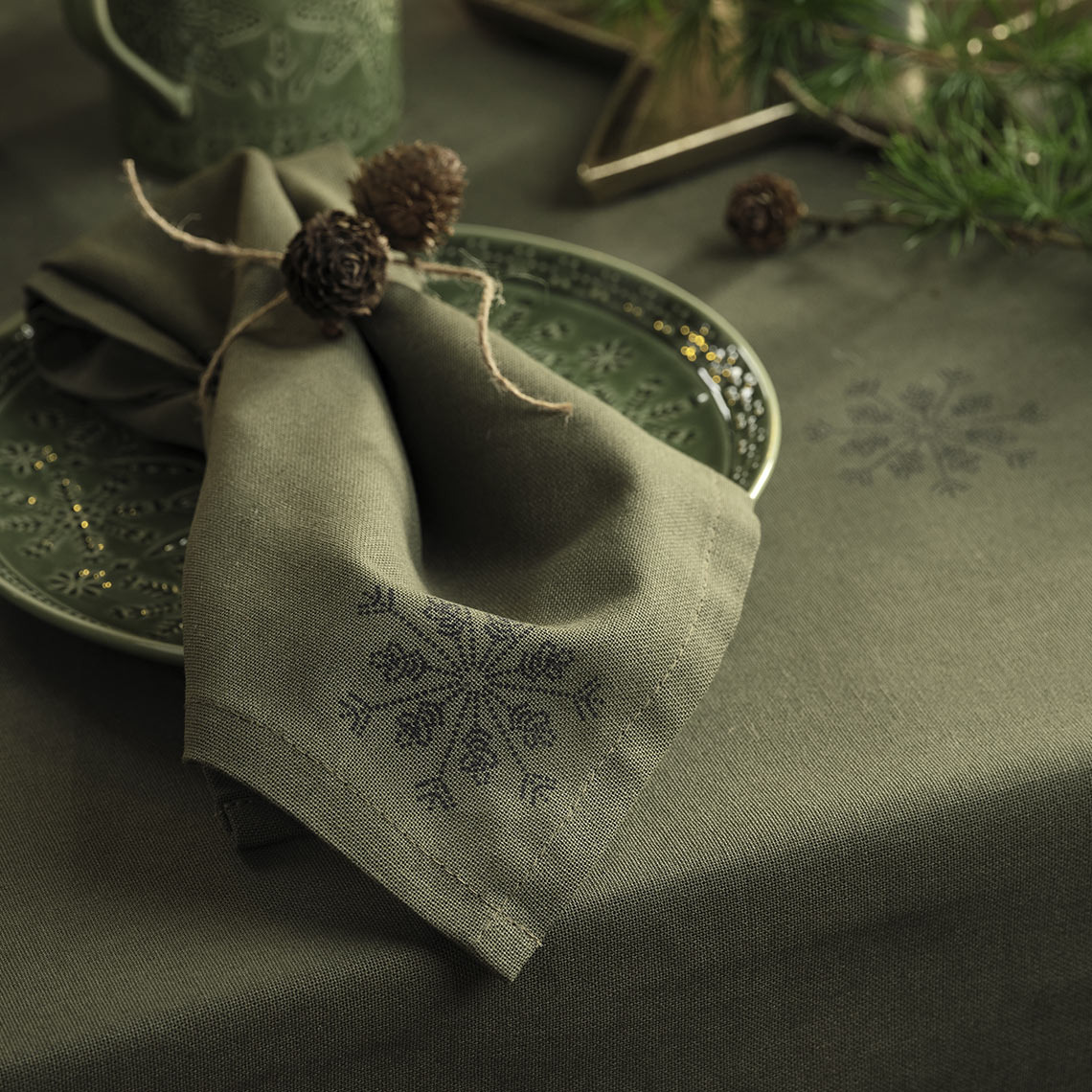 Groen kersttafelkleed en kerst servet op een groen bord 