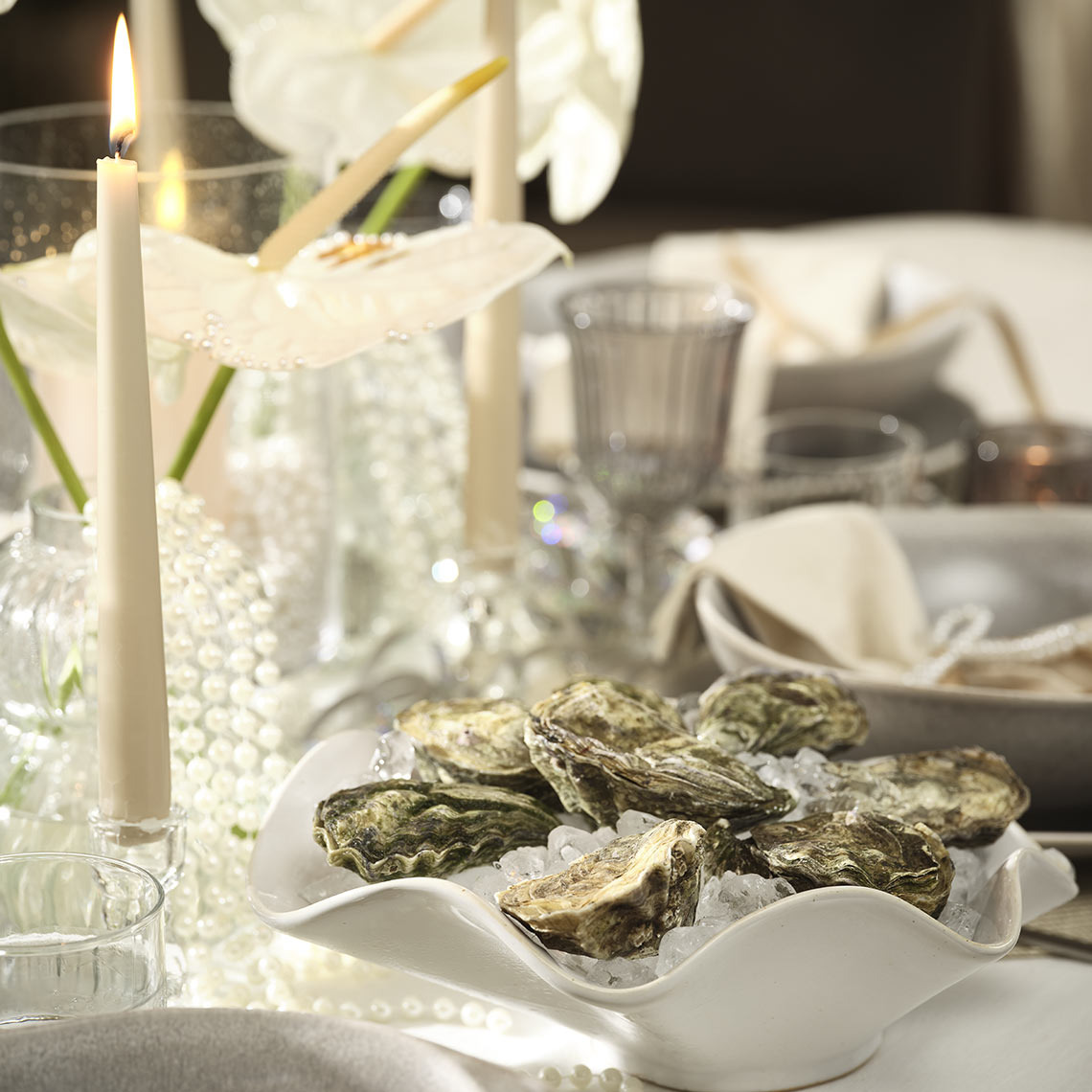 HILMIR kom Kom met oesters op een dinertafel.