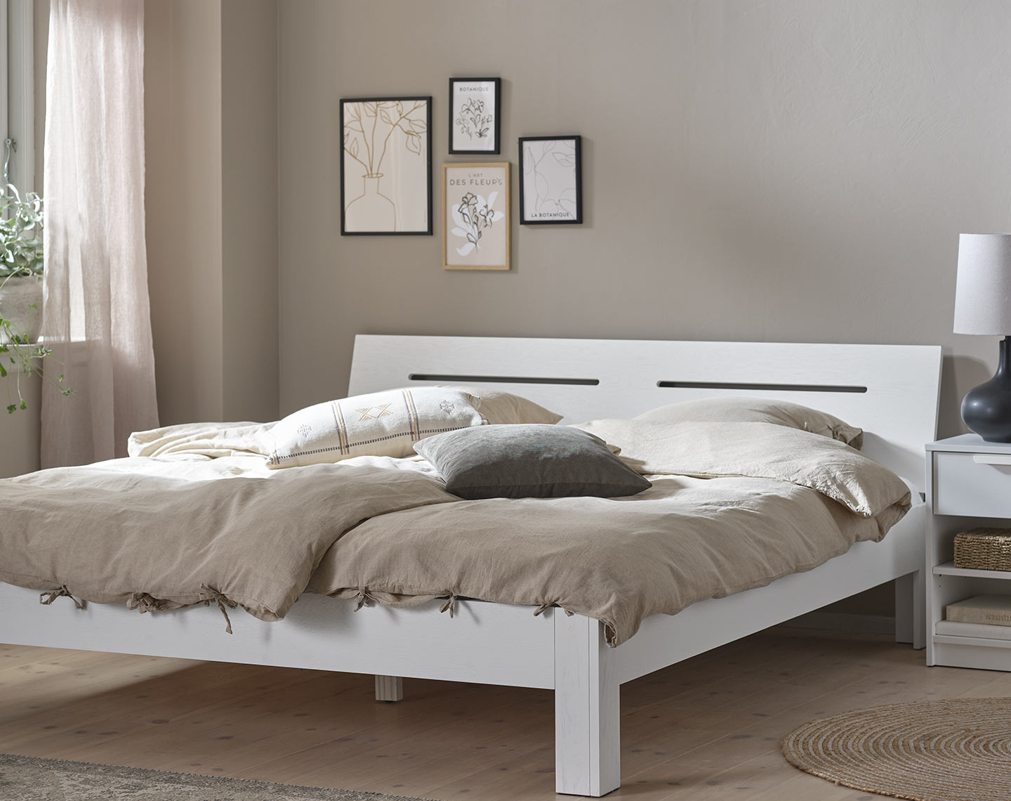 Wit houten bedframe in een slaapkamer