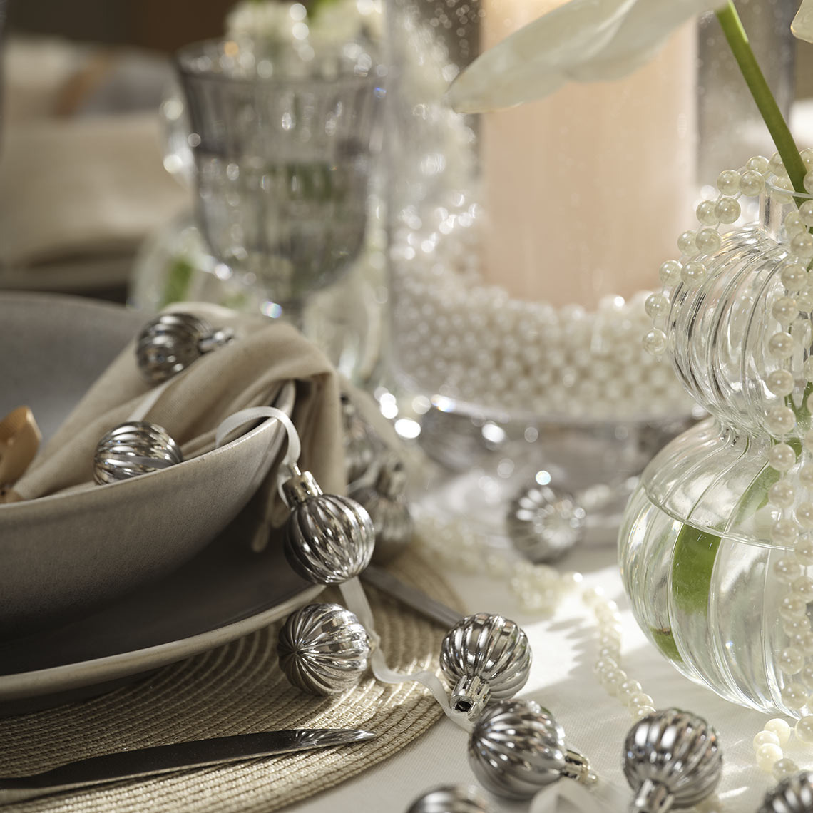 Boules de Noël HELIOTROP Boules de Noël suspendues à une ficelle sur une table à manger