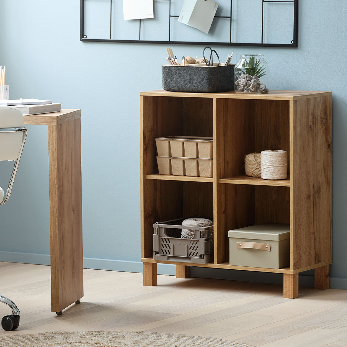 Modulaire wandopbergkast met vier compartimenten, staand op de vloer met bijpassende poten