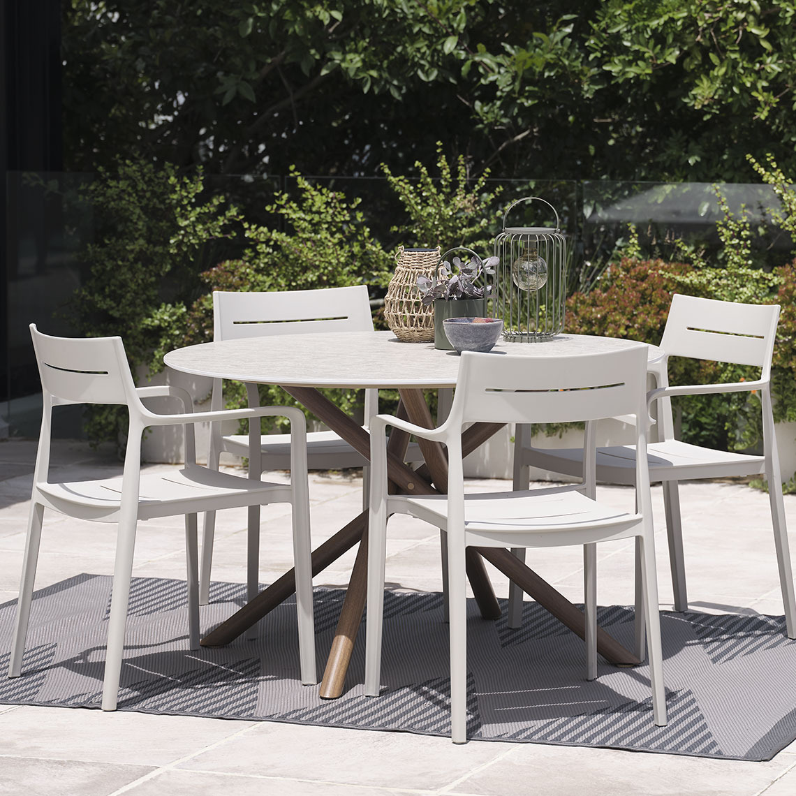 Ronde tuintafel en tuinstoelen op een terras in een tuin  