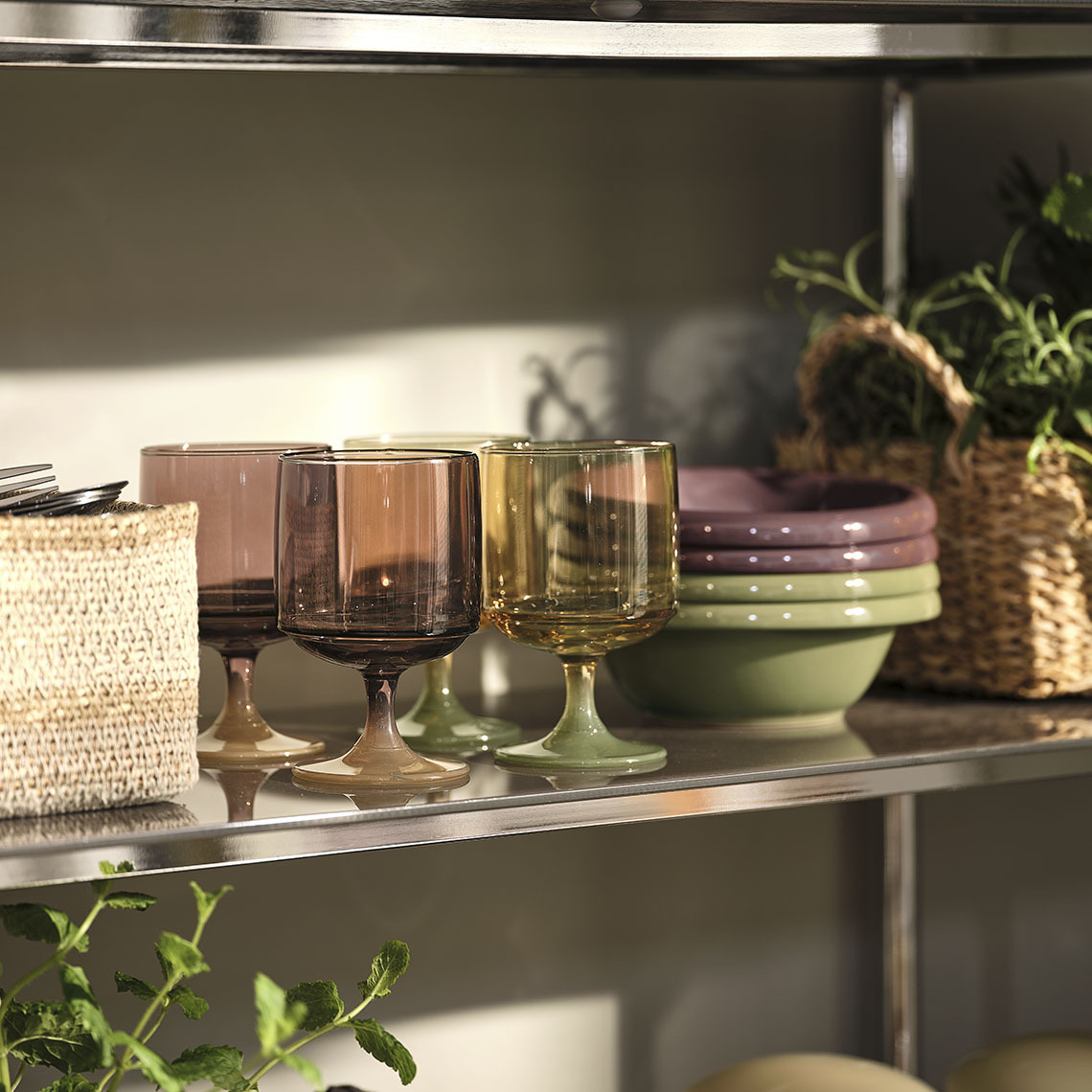 Verres colorés et bols sur une étagère