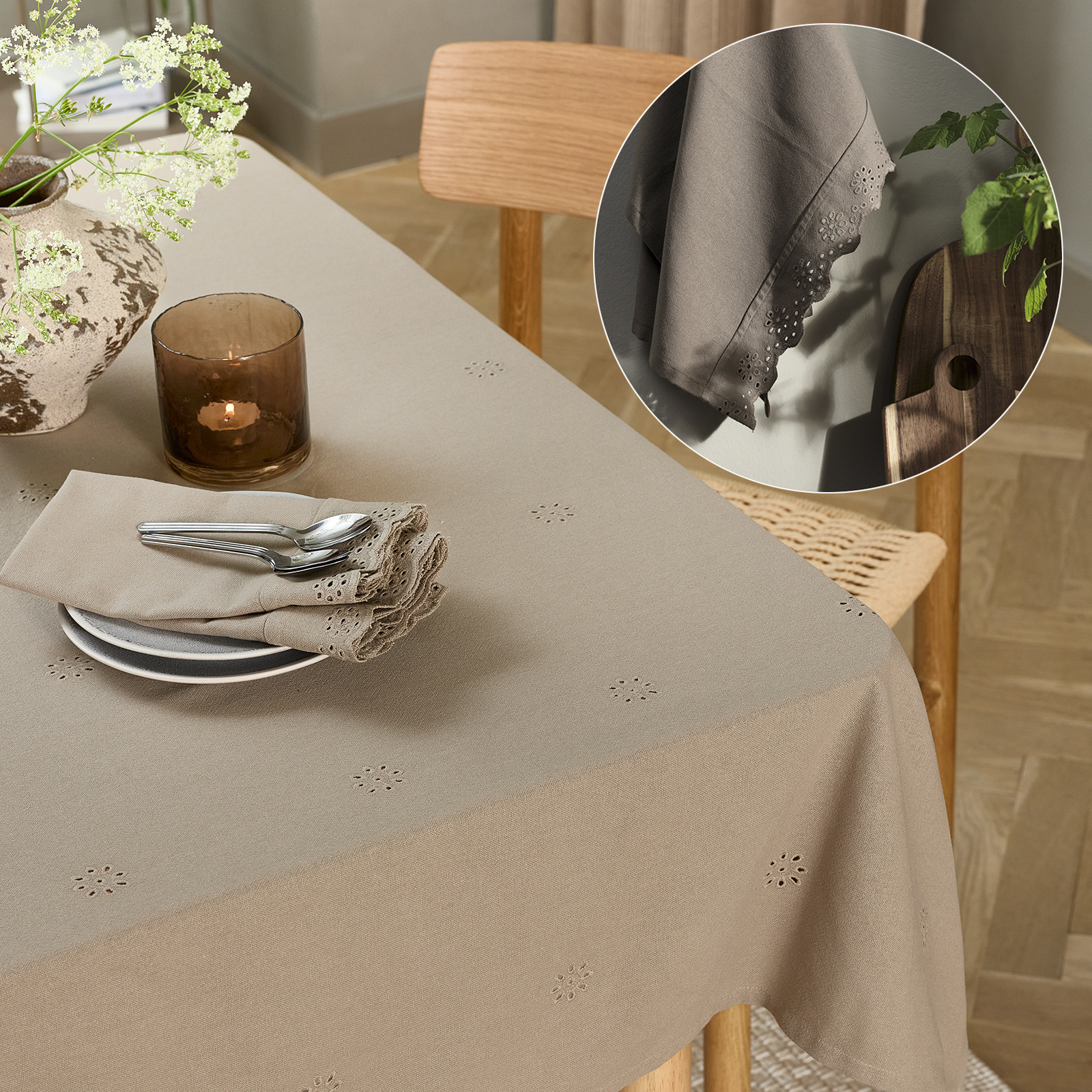 Een gedekte tafel met een tafelkleed, borden en stoffen servetten
