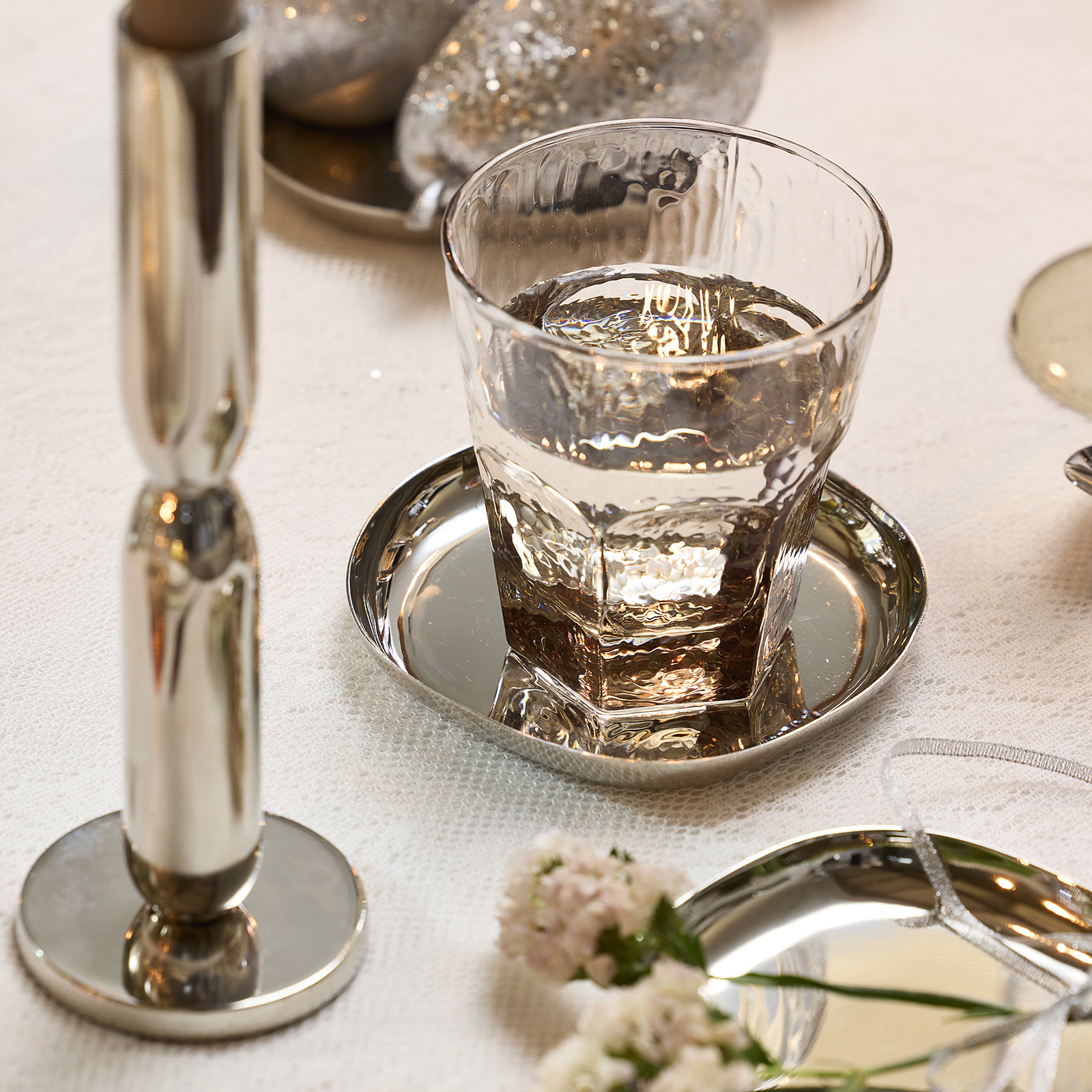 Glas op een zilverkleurige onderzetter op de eettafel