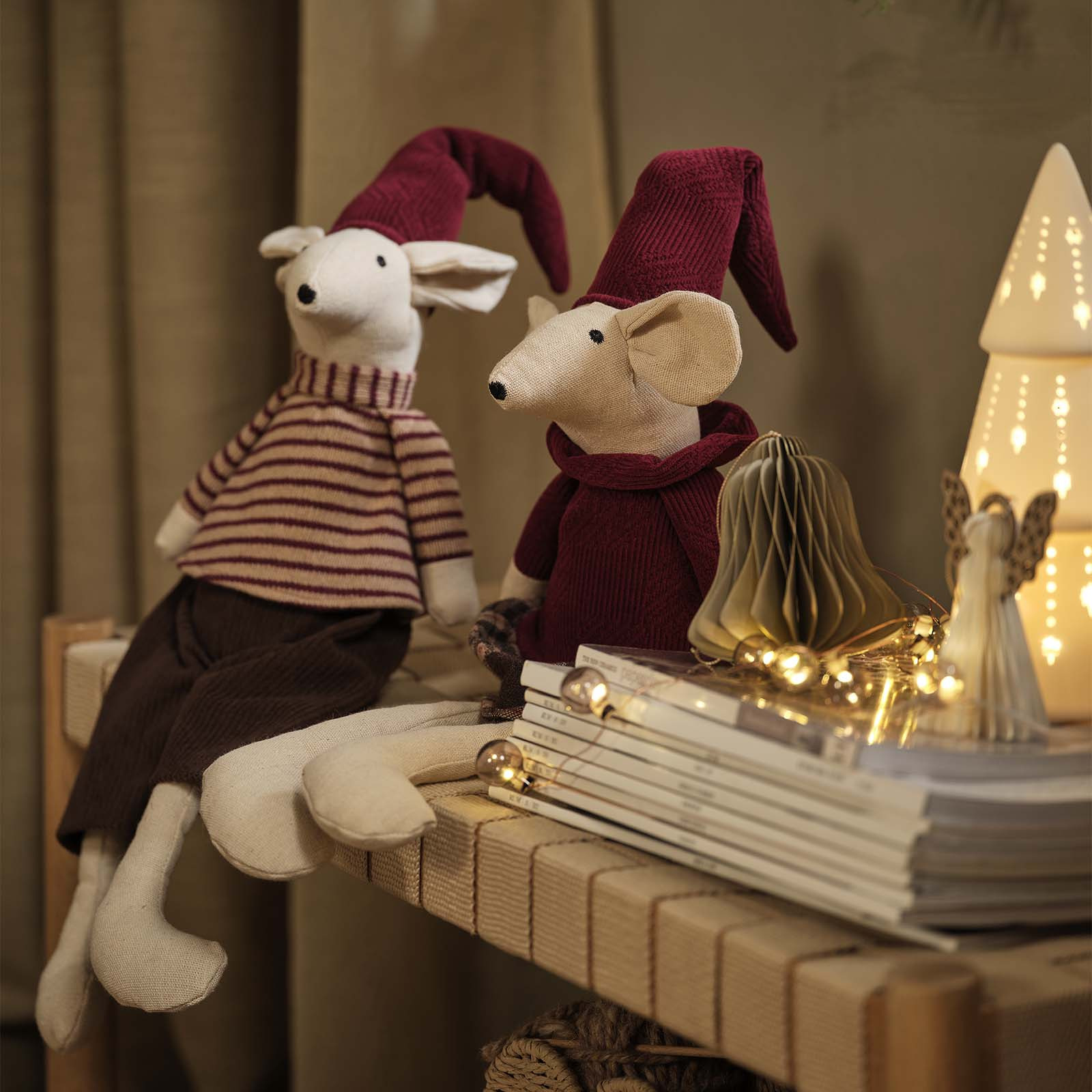 Les souris de Noël JULKLAPP Souris décoratives de Noël avec des bonnets pointus bordeaux, posées sur une banquette.