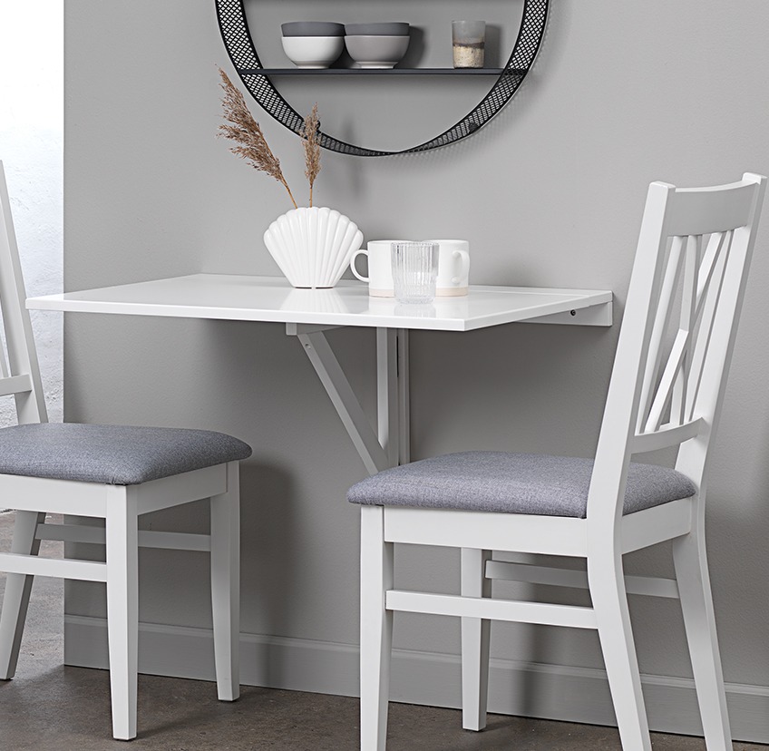 White wall mounted folding table and two dining chairs in kitchen nook