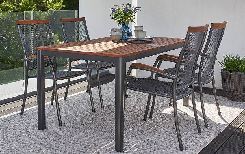 YTTRUP garden table and LARVIK stacking chairs Garden furniture out of metal and hardwood on a patio