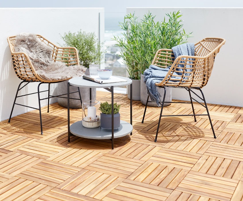 ILDERHUSE lounge chairs and OTTA lounge table on a patio with KNEKKAND wooden deck tiles Lounge chairs and a lounge table on a patio with wooden deck tiles