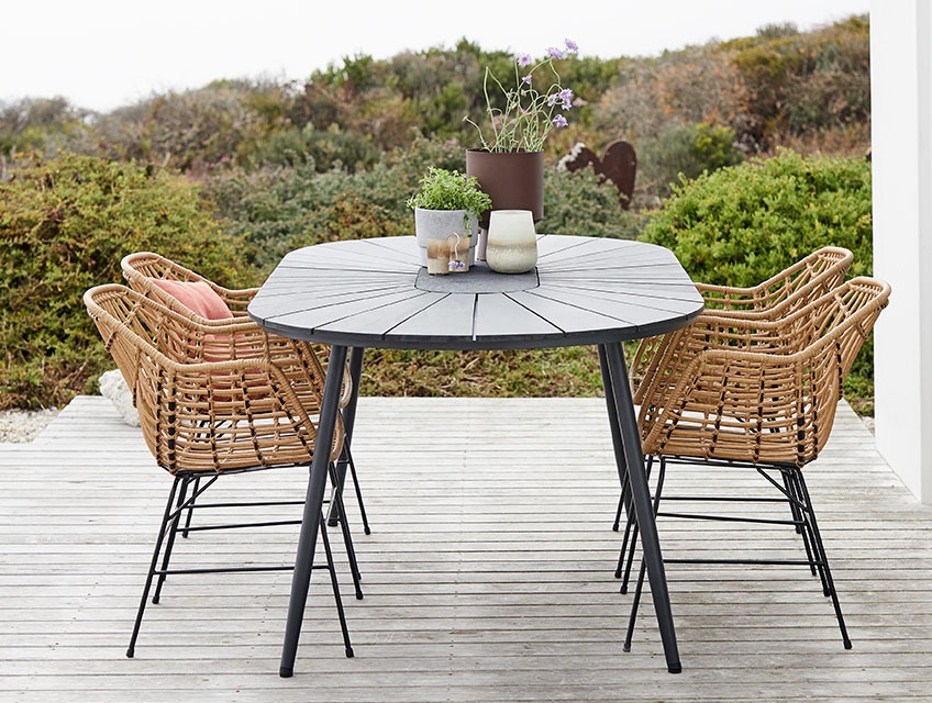 Garden dinging set with table in artwood and chairs in rattan on a patio 