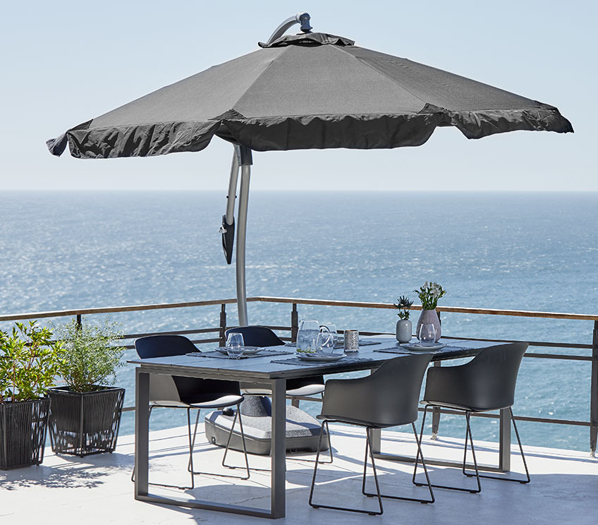 Patio with a HAUGESUND hanging parasol over KOPERVIK garden table and SANDVED garden chairs Patio with a hanging parasol over a garden set