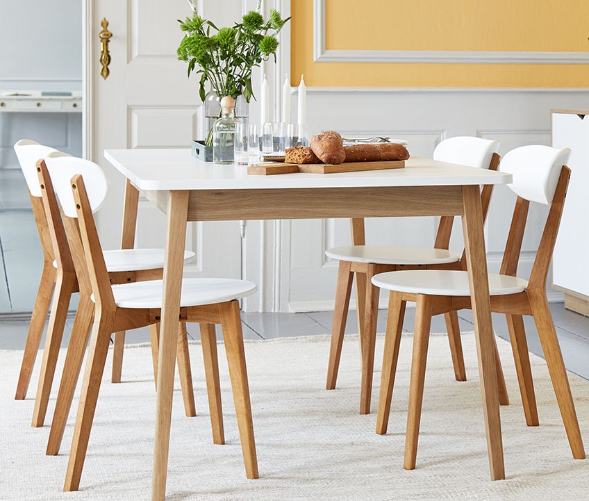 4 houten eetkamerstoelen aan een houten eettafel