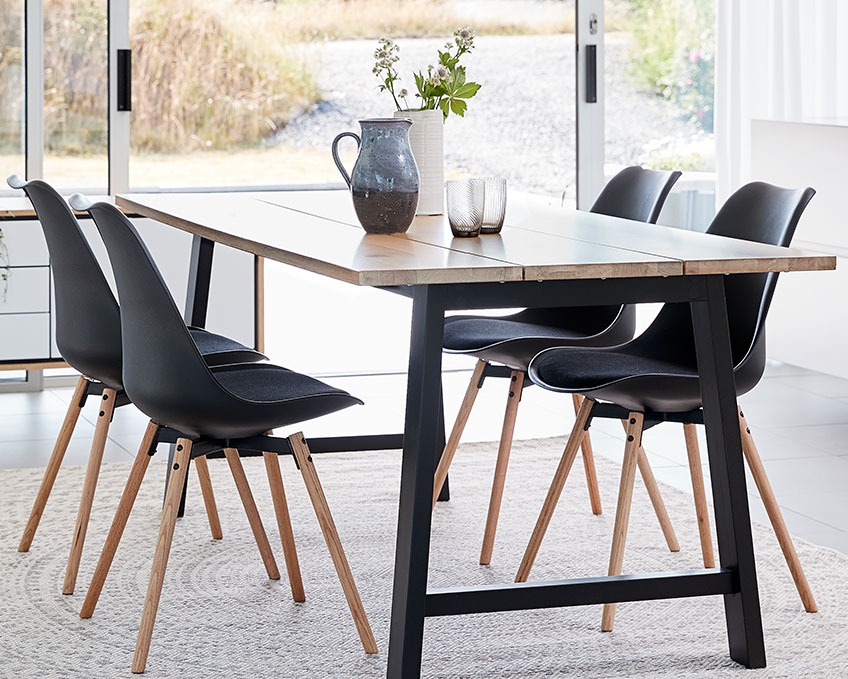 KASTRUP eetkamerstoelen aan de GADESKOV eettafel Vier zwarte eetkamerstoelen aan een eettafel