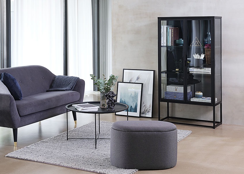 Oval pouffe in a living room with sofa, coffee table and a display cabinet
